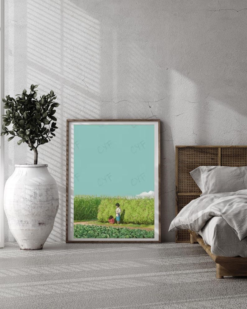 May include: A framed art print depicts two children in a field of green plants under a light blue sky. The artwork is displayed in a room with a large white vase holding a plant, and a bed with a woven headboard.