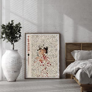 May include: A framed poster featuring a character from the animated film "Spirited Away." The artwork depicts a young girl surrounded by white objects, with Japanese text in the upper left corner. The poster is displayed in a room with a plant and a bed.