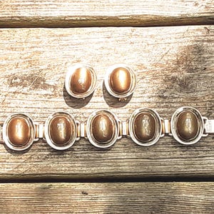 Signed Berger'e Vintage Jewelry Set: Moonglow Stone Bracelet and Clip Earrings from  Yours, Occasionally. Marvelous bracelet and clip earrings make up this set featuring a minimalist design of oval links. The bracelet is 7 7/8" long and 1 1/8" wide while the earrings are 1 3/8" long and  1 1/8" wide. The set shows a bit of wear, but I still rate it as being in excellent vintage* condition.