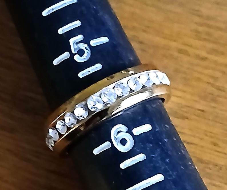 Clear Rhinestone Costume Ring US Sz 5.5 Statement Engagement Cocktail from Yours, Occasionally. Sparkly and simple, this ring is a US size 5 1/2 ladies ring. Whether you use it as an engagement or friendship ring it makes a lovely statement. The gold tone setting has bezel set clear rhinestones all the way around it. The ring is in excellent vintage* condition.