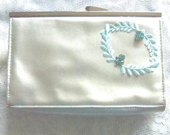 Gedecoreerde make-uptas: zilvergrijze clutch met aqua-strass-appliqué