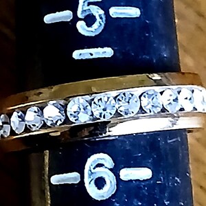 Clear Rhinestone Costume Ring US Sz 5.5 Statement Engagement Cocktail from Yours, Occasionally. Sparkly and simple, this ring is a US size 5 1/2 ladies ring. Whether you use it as an engagement or friendship ring it makes a lovely statement. The gold tone setting has bezel set clear rhinestones all the way around it. The ring is in excellent vintage* condition.