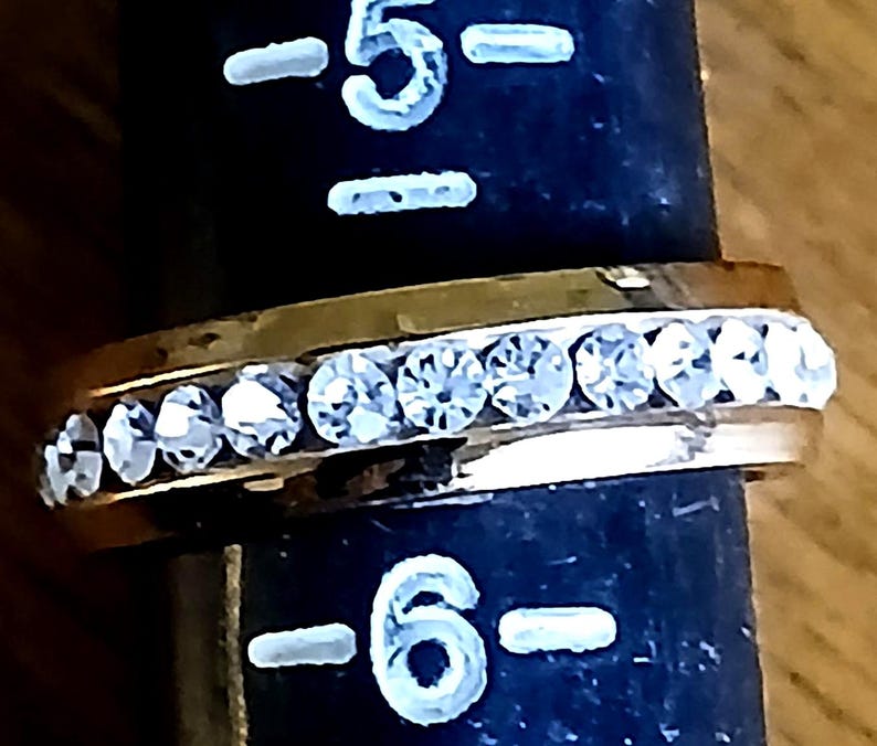 Clear Rhinestone Costume Ring US Sz 5.5 Statement Engagement Cocktail from Yours, Occasionally. Sparkly and simple, this ring is a US size 5 1/2 ladies ring. Whether you use it as an engagement or friendship ring it makes a lovely statement. The gold tone setting has bezel set clear rhinestones all the way around it. The ring is in excellent vintage* condition.