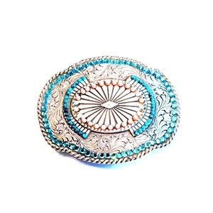 Ornate Belt Buckle Silver Tone Sunburst Design Rhinestones and Beads: Vintage Western Wear from Yours, Occasionally. Marvelous Floral and Sunburst designed buckle features turquoise colored rhinestones around outer edge with turquoise and coral beads in center. It is 3 3/4" long and 3" wide. The vintage* buckle is in excellent vintage* condition. It has been repaired as 4 beads in center were missing. See pictures 4 and 5.