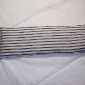 May include: A white and blue striped fabric heating pad. The pad is rectangular and has a seam down the center.