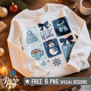 May include: White sweatshirt with a "Cozy Winter" design. The design includes a blue hat, scarf, mug of hot chocolate, snowman, bow, and snowflake. The bottom of the image has the text "FREE 6 PNG SPECIAL DESIGNS".