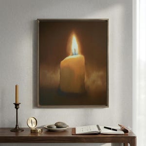 Pu&ograve; includere: Una stampa artistica da parete incorniciata che raffigura una singola candela accesa con una fiamma luminosa su uno sfondo scuro e suggestivo. L'opera &egrave; esposta sopra una scrivania in legno con un candelabro in ottone, una bussola, una ciotola con pietre e un taccuino.
