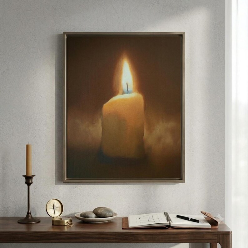 Pu&ograve; includere: Una stampa artistica da parete incorniciata che raffigura una singola candela accesa con una fiamma luminosa su uno sfondo scuro e suggestivo. L'opera &egrave; esposta sopra una scrivania in legno con un candelabro in ottone, una bussola, una ciotola con pietre e un taccuino.