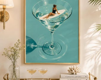 Puede incluir: Una lámina de arte mural enmarcada con una ilustración surrealista de una persona en bañador negro tumbada sobre una tabla de surf blanca dentro de una copa de martini grande llena de líquido transparente sobre un fondo verde azulado.