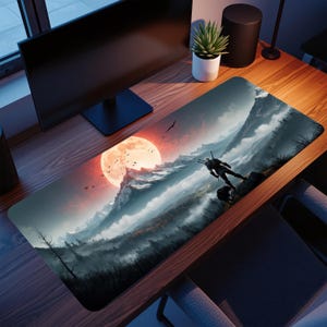 Può includere: Tappetino per mouse rettangolare con un design a paesaggio montano, con un grande sole rosso e una figura con spade. Il design presenta un'illustrazione dettagliata di un terreno montuoso con una persona in piedi su una roccia. La tavolozza dei colori include sfumature di rosso, grigio e blu.