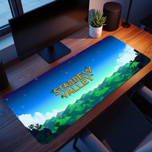 May include: A rectangular desk mat with the words "Stardew Valley" in yellow with green detailing. The mat depicts a landscape with green hills, a blue sky, and white clouds. The mat is designed for use with a computer and measures approximately 80cm in length.