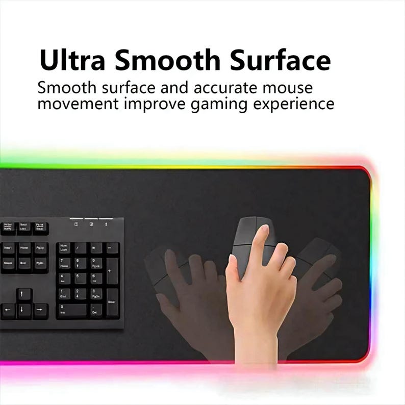 May include: Black rectangular gaming mouse mat with a keyboard and a mouse. The mat has a smooth surface and a colourful LED border. The text on the image says "Ultra Smooth Surface".