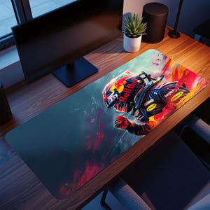 Puede incluir: Alfombrilla de escritorio rectangular con una ilustración dinámica de un piloto de Fórmula 1 con un casco Red Bull. El diseño incorpora colores rojo, naranja y azul, con el logotipo de Red Bull. La alfombrilla está sobre un escritorio de madera.