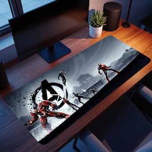 Pode incluir: Tapete de mesa retangular com uma ilustração em tons de cinza de personagens dos Vingadores em ação. O logotipo dos Vingadores é visível. O tapete tem uma borda preta e é projetado para uso com um computador.