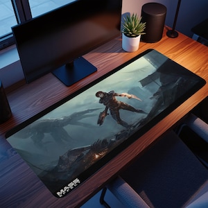 May include: A black rectangular desk mat with a sci-fi illustration of a figure with a weapon, and a large creature in the background. The words "MASS EFFECT" are printed in white at the bottom left corner.