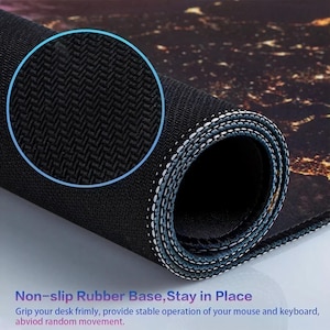 May include: Rolled-up black and brown mouse mat with a non-slip rubber base. The mat features a detailed pattern and white stitching along the edges. Text on the mat reads "Non-slip Rubber Base, Stay in Place".