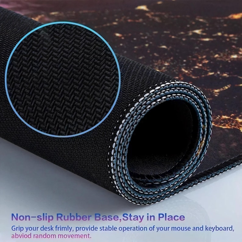 May include: Rolled-up black and brown mouse mat with a non-slip rubber base. The mat features a detailed pattern and white stitching along the edges. Text on the mat reads "Non-slip Rubber Base, Stay in Place".