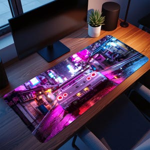 Pode incluir: Um mousepad retangular com um carro esportivo branco com luzes traseiras vermelhas dirigindo em uma rua molhada à noite. A cena é iluminada por luzes de néon em tons de rosa, roxo e azul, criando uma estética urbana vibrante.