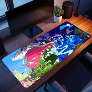 Puede incluir: Alfombrilla de escritorio rectangular con un diseño dividido. Un lado muestra un paisaje colorido con un arcoíris, el otro una escena de montaña geométrica en tonos azules. La alfombrilla está diseñada para un escritorio de ordenador.