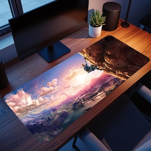May include: A rectangular gaming mousepad with a landscape design, featuring a character climbing a cliff face. The artwork depicts a sunset with pink, orange, and blue colours, and a detailed mountain range.