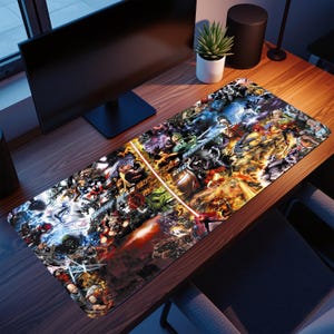 May include: A rectangular desk mat featuring a vibrant collage of comic book characters in various action poses. The mat has a red laser-like design element and is placed on a wooden desk with a computer monitor and speakers.