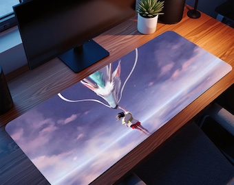May include: A rectangular desk mat with a fantasy illustration of a white and blue dragon interacting with a person against a purple and blue sky background. The mat is designed for use with a computer mouse and keyboard.