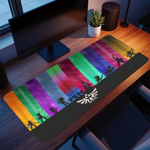 May include: A rectangular desk mat with a vibrant, abstract design of vertical stripes in various colours. Black silhouettes of characters and the Triforce symbol are featured. Ideal for a gaming setup, it measures approximately 80 cm in length.