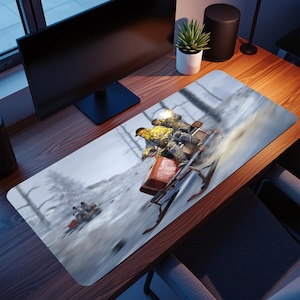 May include: A rectangular desk mat depicting a winter scene with a snowmobile racing down a snowy hill. The mat shows a red and brown snowmobile with two people wearing yellow jackets. The background shows a snowy forest.
