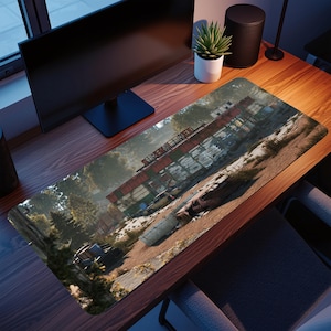 May include: A rectangular desk mat with a detailed image of a post-apocalyptic landscape. The design features a rusted industrial structure, abandoned vehicles, and overgrown vegetation. The mat has a brown and green colour palette, with the text "SERPERMEEKER".