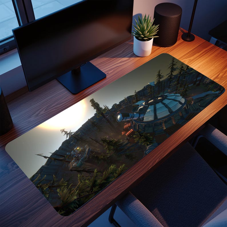May include: A rectangular desk mat depicting a futuristic landscape with a detailed structure and a mountain range. The mat has a dark background with a bright, sunlit sky. The mat is on a wooden desk with a computer monitor and speakers.