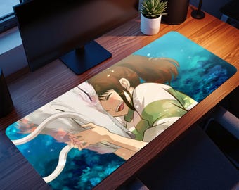 May include: A rectangular mouse mat with a colourful anime-style illustration. The design depicts a character embracing a white dragon-like creature against a blue and green backdrop. The mat is designed for computer use.