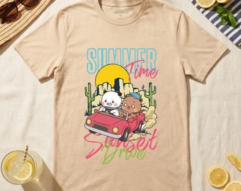 May include: Beige t-shirt with a graphic of two cartoon characters in a red convertible car, driving past a desert landscape with a setting sun. The text "Summer Time Sunset Drive" is printed on the shirt.