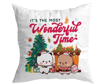 May include: White square pillow with a Christmas theme. The pillow features two cartoon bears, a Christmas tree, and the text "IT'S THE MOST Wonderful Time" in red and green. Presents and stockings are also visible.