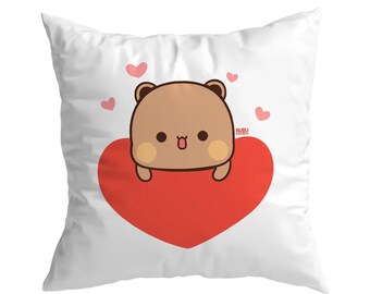 May include: White square pillow featuring a cartoon bear character with a brown body, tan ears and cheeks, and a red heart. The bear is positioned on top of the heart, with small pink hearts scattered around the design. The text "BUBU & COCO" is in the corner.