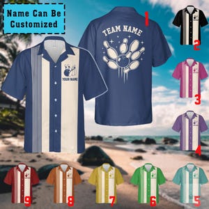 Puede incluir: Una camisa de bolos de manga corta con un panel de rayas verticales en la parte delantera y un gráfico de bolos en la parte posterior. El diseño incluye áreas de texto personalizables etiquetadas como 'YOUR NAME' y 'TEAM NAME'. Se muestran varias variantes de color.
