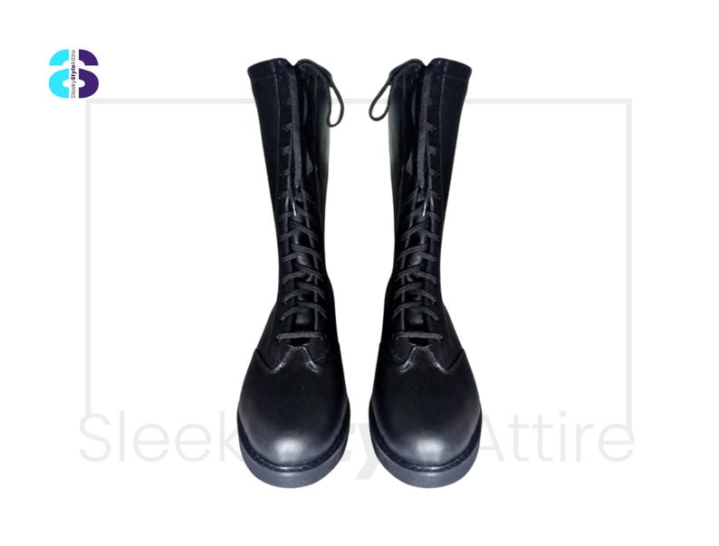Puede incluir: Un par de botas negras hasta la rodilla con dise&ntilde;o de cordones. Las botas tienen punta redondeada y tac&oacute;n bajo. Las botas est&aacute;n hechas de un material liso similar al cuero. Las botas se muestran sobre un fondo blanco.