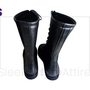Puede incluir: Un par de botas de cuero negro con ca&ntilde;a alta y dise&ntilde;o de cordones. Las botas tienen una cremallera lateral y una puntera redondeada. Las botas son de cuero liso y brillante.