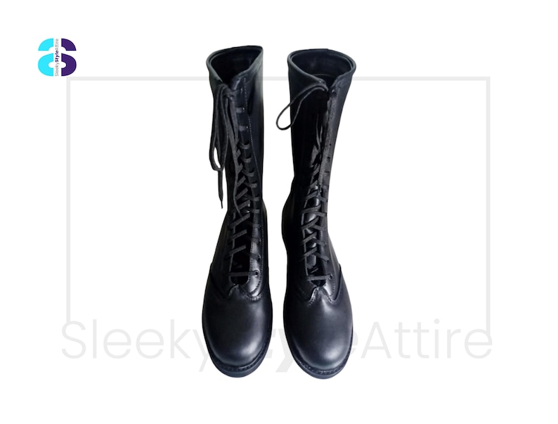 Puede incluir: Un par de botas negras hasta la rodilla con dise&ntilde;o de cordones. Las botas tienen un aspecto de cuero liso y una puntera redondeada. Los cordones suben por la parte delantera de las botas. Las botas se muestran sobre un fondo blanco.