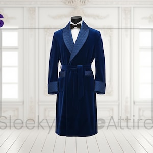 Op de afbeelding: Een marineblauwe fluwelen badjas met een sjaalkraag en bijpassende riem wordt op een mannequin gepresenteerd. De badjas heeft een gewatteerd patroon op de revers, manchetten en zakken. Een zwarte vlinderdas is zichtbaar bij de hals. De tekst "Sleeky Attire" staat onderaan.