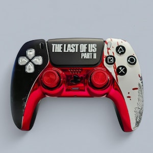 Op de afbeelding: Aangepaste PlayStation 5-controller met een zwart, rood en wit ontwerp. De controller heeft de tekst "THE LAST OF US PART II" aan de bovenkant, rode thumbsticks en een zwarte D-pad. De rechterkant is wit met rode spetters.