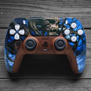 Peut inclure: Une manette de jeu vidéo personnalisée avec un fini grain de bois et un graphisme détaillé d'un arbre noueux et d'un crâne. La manette a des accents bleus et des boutons blancs. Le design est sur une surface en bois foncé.