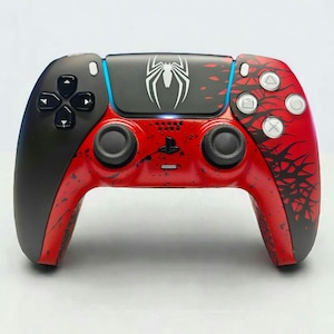 Könnte beinhalten: Individueller PlayStation 5-Controller im Spider-Man-Design, schwarz und rot. Der Controller hat einen schwarzen oberen Bereich mit weißem Spinnenlogo und einen roten unteren Bereich mit schwarzen spinnennetzartigen Designs. Mit den Standard-PlayStation-Tasten.