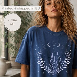 Könnte beinhalten: Ein dunkelblaues Kurzarm-T-Shirt mit einem weißen Grafikdruck von Mondphasen, Sternen und botanischen Zweigen. Das T-Shirt hat einen Rundhalsausschnitt und eine lockere Passform. Der Text midnight ist in der unteren linken Ecke zu sehen.