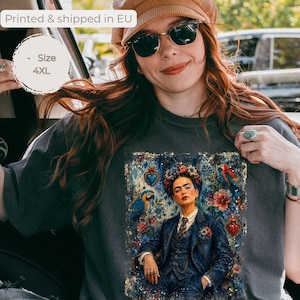 Peut inclure: Un t-shirt gris anthracite avec une impression graphique représentant une personne portant une couronne de fleurs et un costume, entourée de perroquets et de cœurs. Le t-shirt est marqué taille 4XL, couleur pepper, avec une étiquette imprimée en UE.