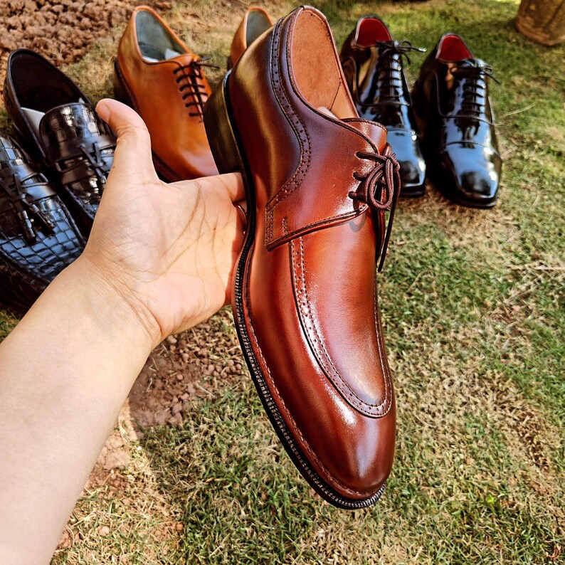 Brown derby shoes for men with smooth leather finish and open lacing design suitable for US, UK, Canada, Australia, Switzerland, and Pakistan markets.