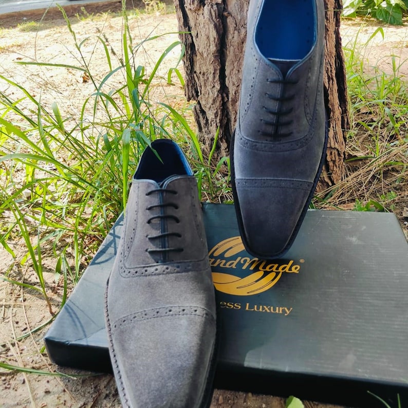Handmade grey suede oxfords with leather sole and cushioned insole, crafted for men’s formal and business wear.
