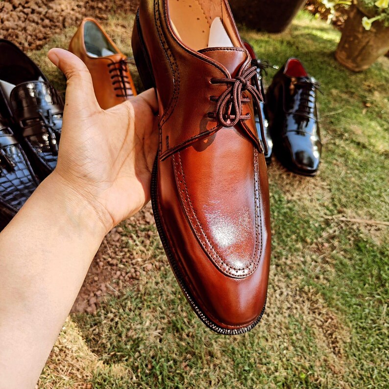 Brown derby shoes for men with smooth leather finish and open lacing design suitable for US, UK, Canada, Australia, Switzerland, and Pakistan markets.