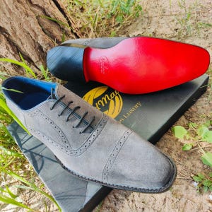 Handmade grey suede oxfords with leather sole and cushioned insole, crafted for men’s formal and business wear.