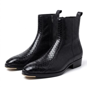 May include: A pair of black ankle boots with a textured, snakeskin-like pattern. The boots have a side zip, a rounded toe, and a small heel. The soles have a gold accent.