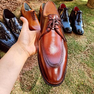 Brown derby shoes for men with smooth leather finish and open lacing design suitable for US, UK, Canada, Australia, Switzerland, and Pakistan markets.